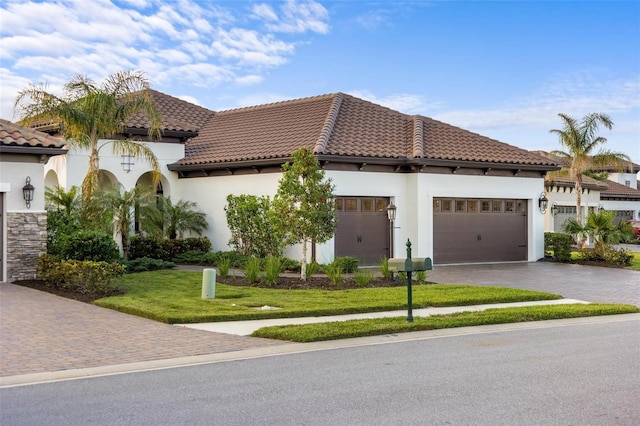 mediterranean / spanish house with a front yard and a garage