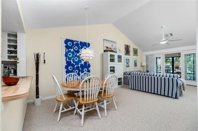 carpeted dining area with ceiling fan and lofted ceiling