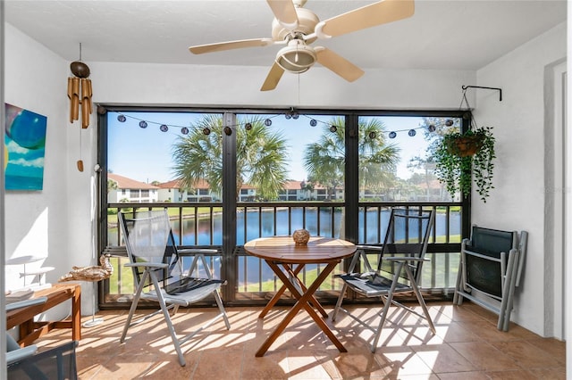 sunroom / solarium with a water view and ceiling fan