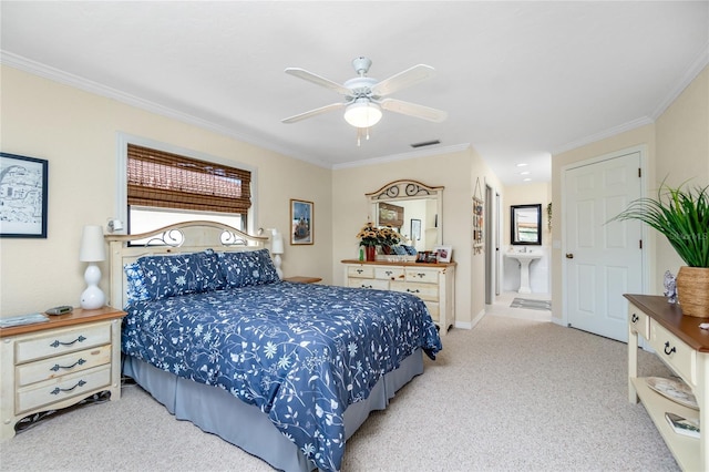 carpeted bedroom with ensuite bath, ceiling fan, and crown molding