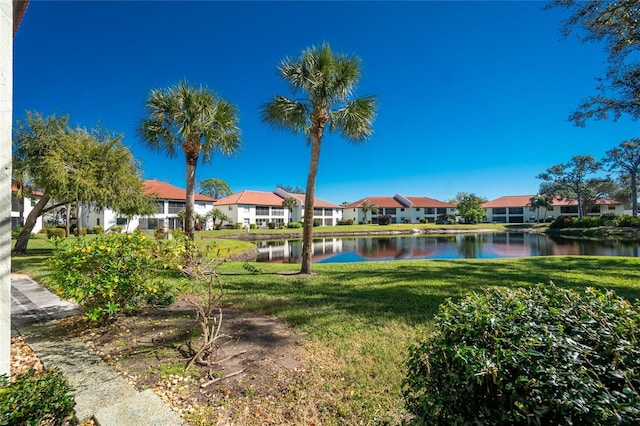 view of property's community with a water view and a yard