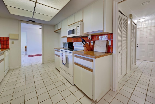 kitchen with decorative backsplash, white cabinetry, light tile patterned floors, and white appliances