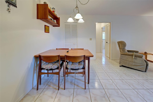 tiled dining area featuring a notable chandelier