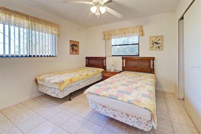 bedroom featuring ceiling fan, light tile patterned flooring, and a closet