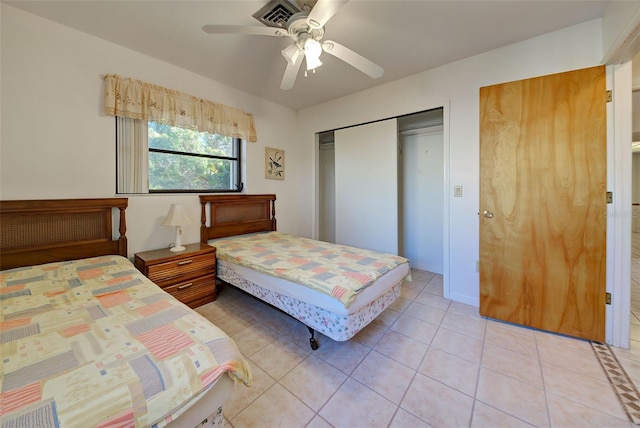 bedroom with ceiling fan, a closet, and light tile patterned floors