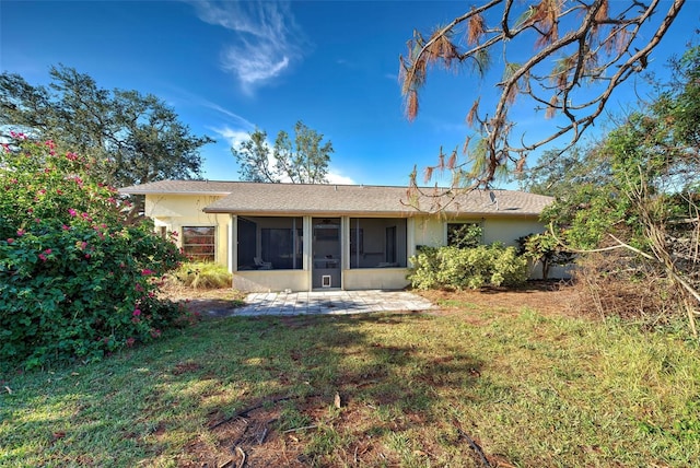 rear view of house featuring a sunroom, a yard, and a patio