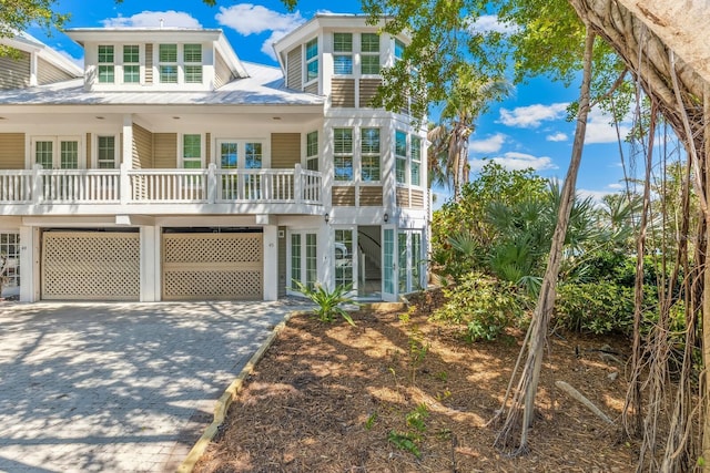 coastal home with french doors and concrete driveway