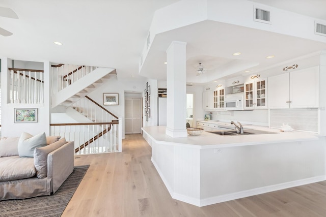 kitchen with visible vents, light wood-style flooring, light countertops, and a sink