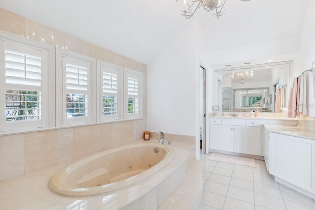 bathroom with vanity, an inviting chandelier, a whirlpool tub, and a wealth of natural light