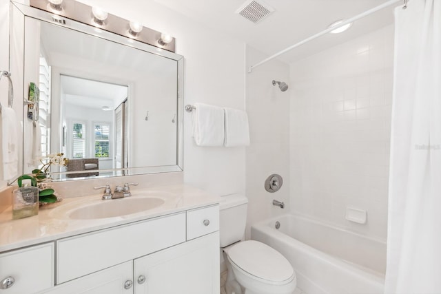 bathroom with visible vents, vanity, toilet, and shower / tub combo