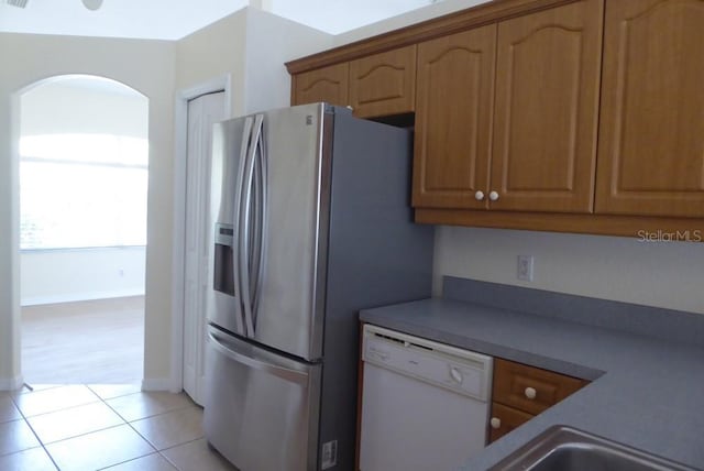 328 Baytree Dr, Rotonda West, FL 33947 - kitchen featuring dishwasher, arched walkways, stainless steel fridge with ice dispenser, and light tile patterned floors