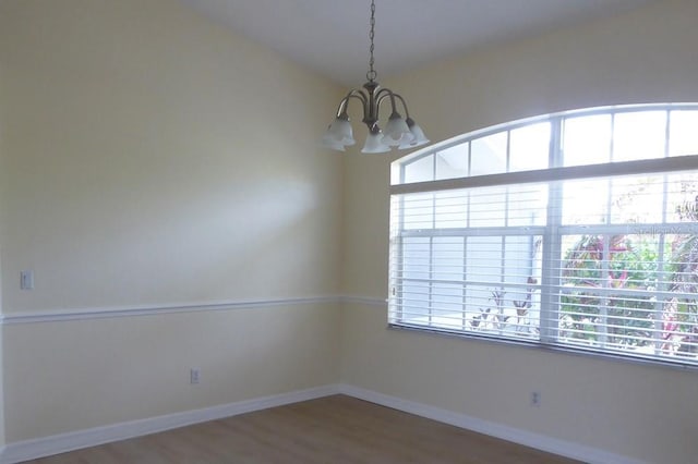 328 Baytree Dr, Rotonda West, FL 33947 - spare room featuring a chandelier, wood finished floors, and baseboards