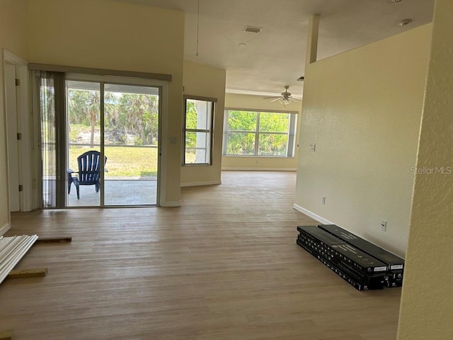 328 Baytree Dr, Rotonda West, FL 33947 - unfurnished living room featuring baseboards, a ceiling fan, and wood finished floors