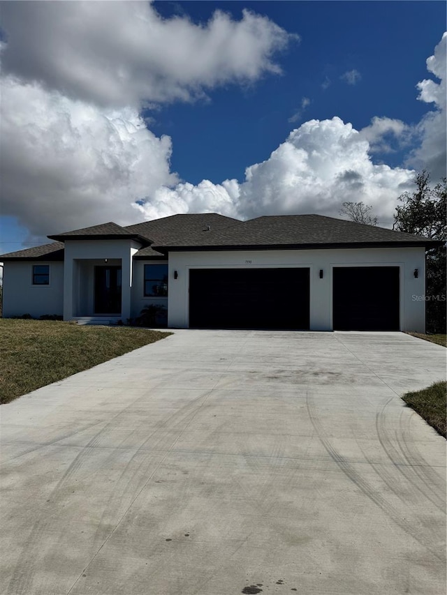 view of front of property with a garage and a front lawn