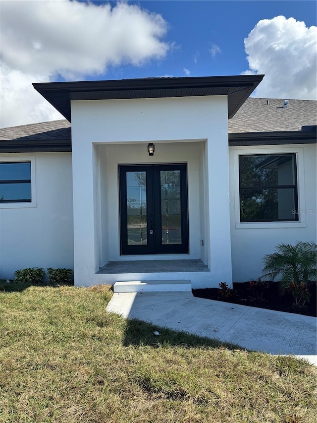 property entrance featuring a lawn and french doors