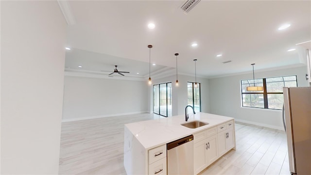 kitchen with pendant lighting, sink, white cabinets, a kitchen island with sink, and stainless steel appliances