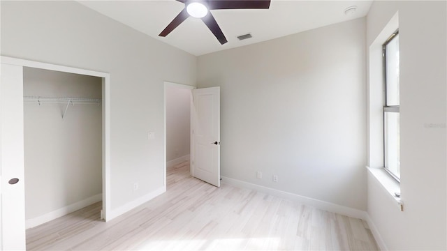 unfurnished bedroom with ceiling fan, light wood-type flooring, and a closet