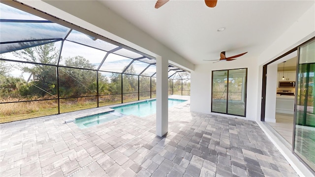 view of pool with a lanai, ceiling fan, and a patio area