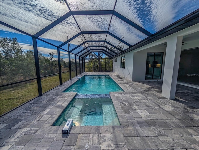 view of swimming pool with a lanai, a patio area, and ceiling fan