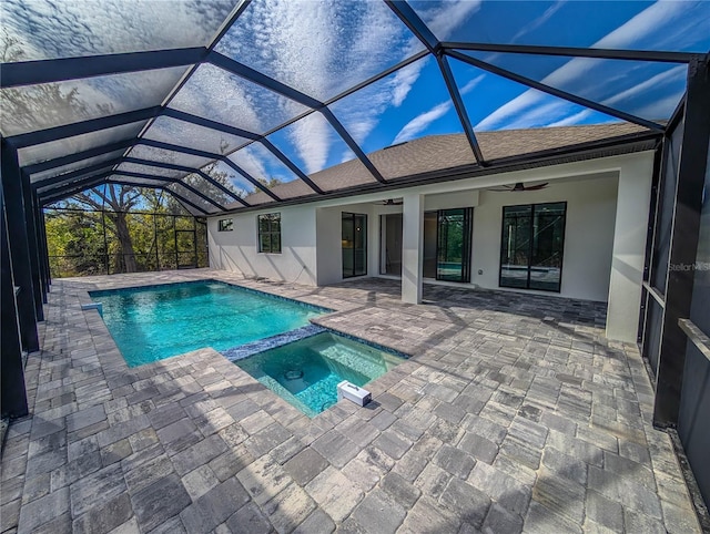 view of swimming pool with an in ground hot tub, a patio, ceiling fan, and glass enclosure