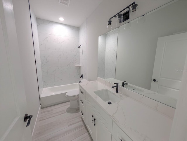 full bathroom featuring vanity, toilet, and tiled shower / bath combo