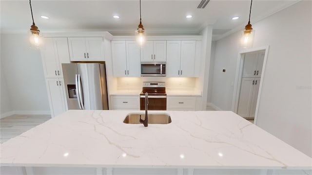 kitchen with stainless steel appliances, a kitchen island with sink, and decorative light fixtures