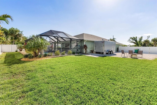 back of property featuring a yard, a patio, and glass enclosure