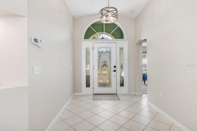 tiled entrance foyer with a chandelier, high vaulted ceiling, and a healthy amount of sunlight