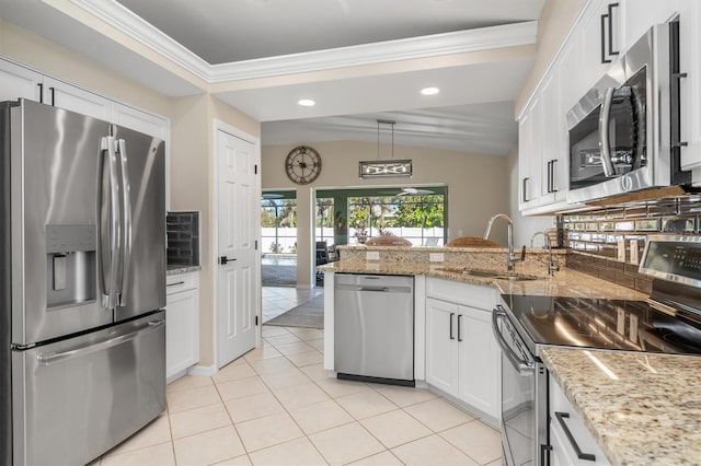 kitchen featuring pendant lighting, backsplash, white cabinets, sink, and appliances with stainless steel finishes