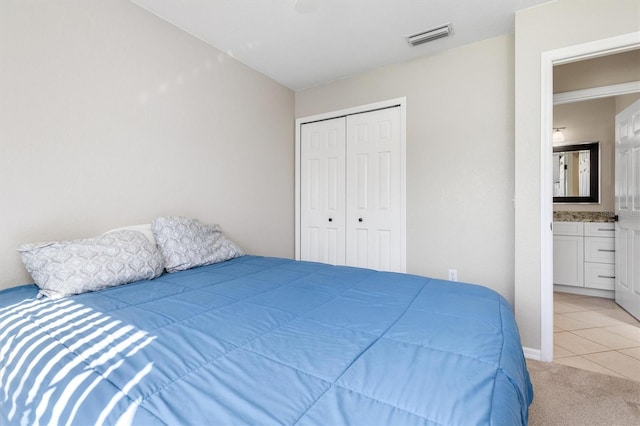 carpeted bedroom with connected bathroom and a closet