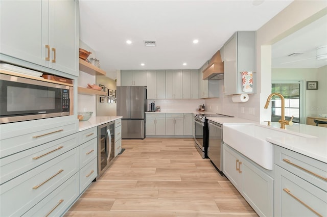 kitchen with backsplash, custom exhaust hood, stainless steel appliances, sink, and wine cooler