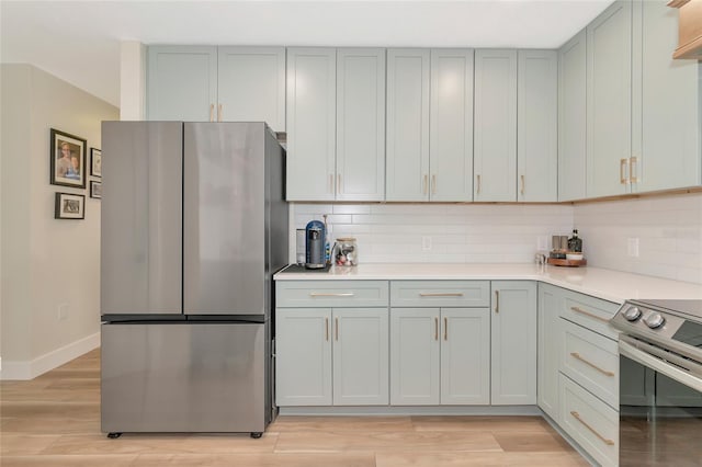 kitchen featuring backsplash, stainless steel appliances, and light hardwood / wood-style flooring