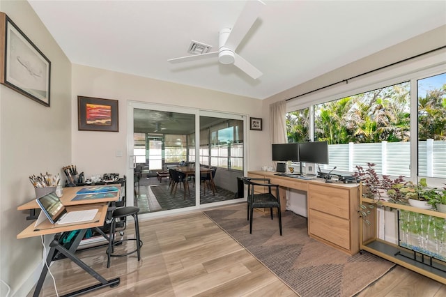 home office featuring ceiling fan, light hardwood / wood-style flooring, and a healthy amount of sunlight