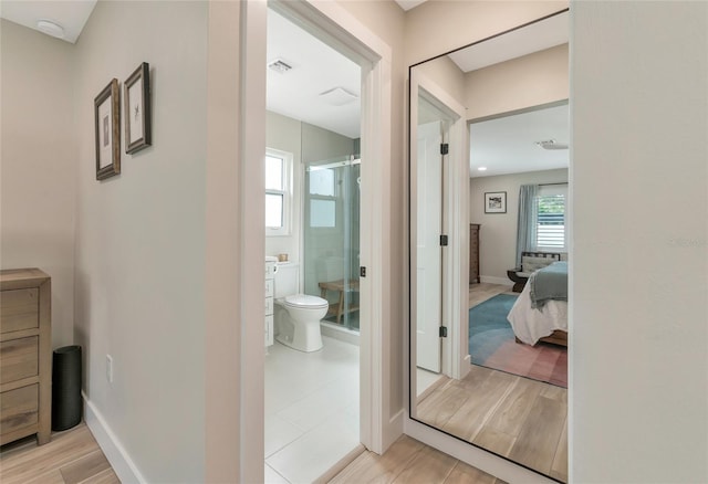 bathroom featuring vanity, toilet, and a shower with door