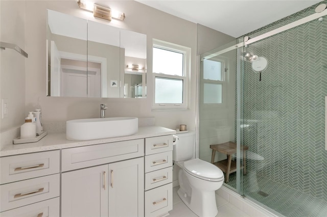 bathroom featuring tile patterned floors, vanity, a shower with shower door, and toilet