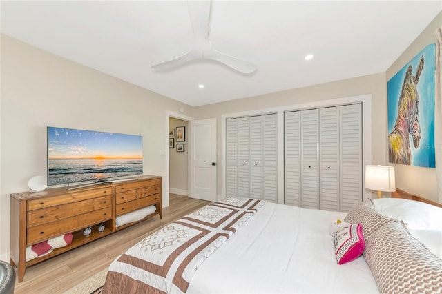 bedroom with ceiling fan, two closets, and light wood-type flooring