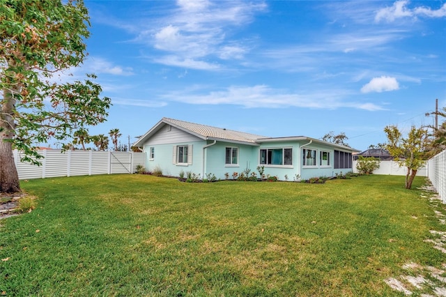 rear view of property featuring a lawn