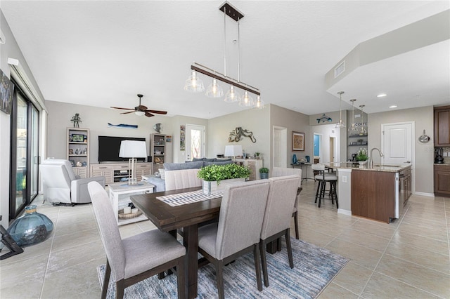 tiled dining room featuring ceiling fan and sink