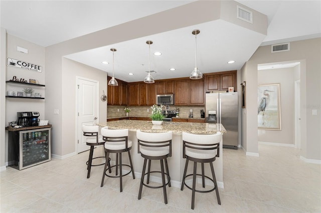 kitchen with decorative light fixtures, stainless steel appliances, a kitchen island, and a kitchen breakfast bar