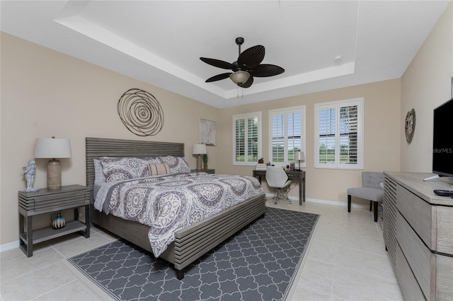 tiled bedroom featuring a tray ceiling and ceiling fan