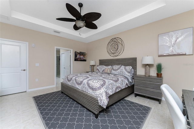 tiled bedroom featuring a raised ceiling and ceiling fan