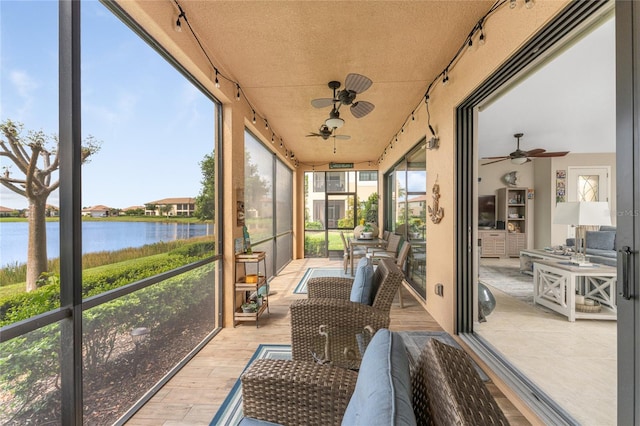 sunroom / solarium featuring ceiling fan, plenty of natural light, and a water view