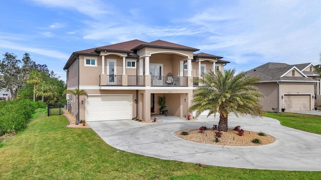 view of front facade with a balcony, a front yard, and a garage