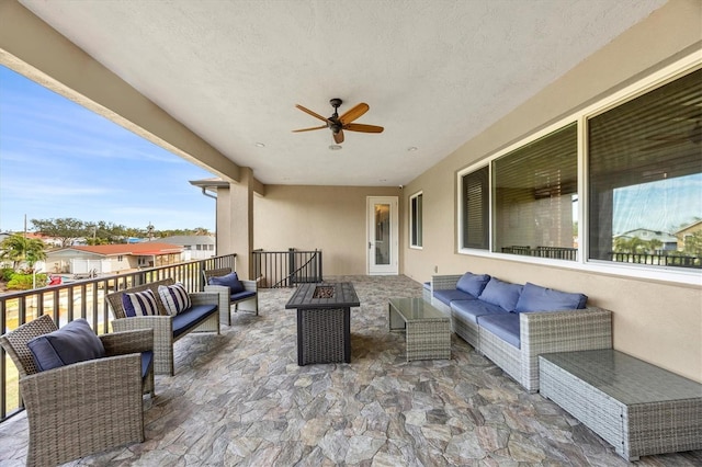 view of patio with ceiling fan and an outdoor living space with a fire pit