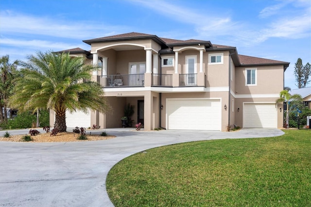 view of front of property featuring a balcony, a front yard, and a garage