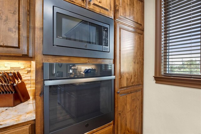 interior details with decorative backsplash and appliances with stainless steel finishes