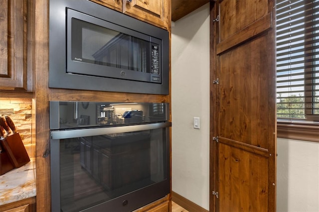 details with decorative backsplash, oven, and built in microwave