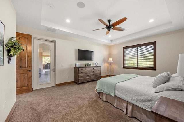 bedroom with ceiling fan, light colored carpet, access to outside, and a tray ceiling