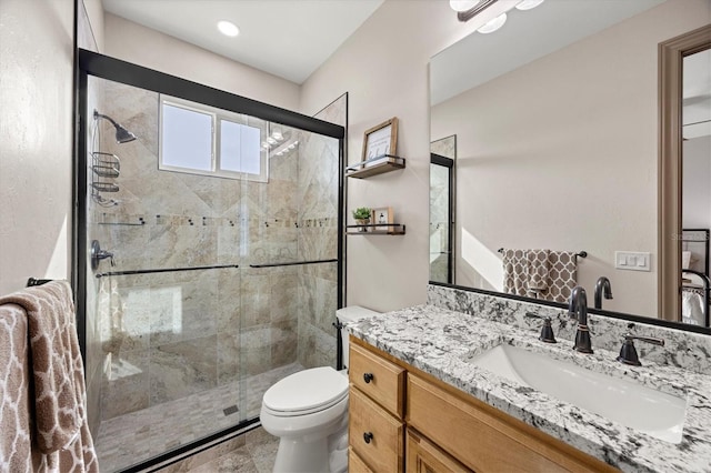 bathroom featuring toilet, vanity, and walk in shower