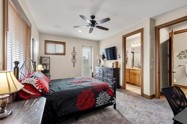 bedroom with ensuite bathroom, ceiling fan, sink, and light carpet